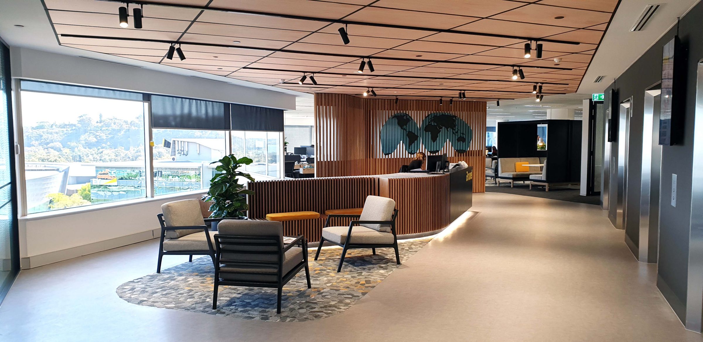 Three chairs in office reception area with global map beyond