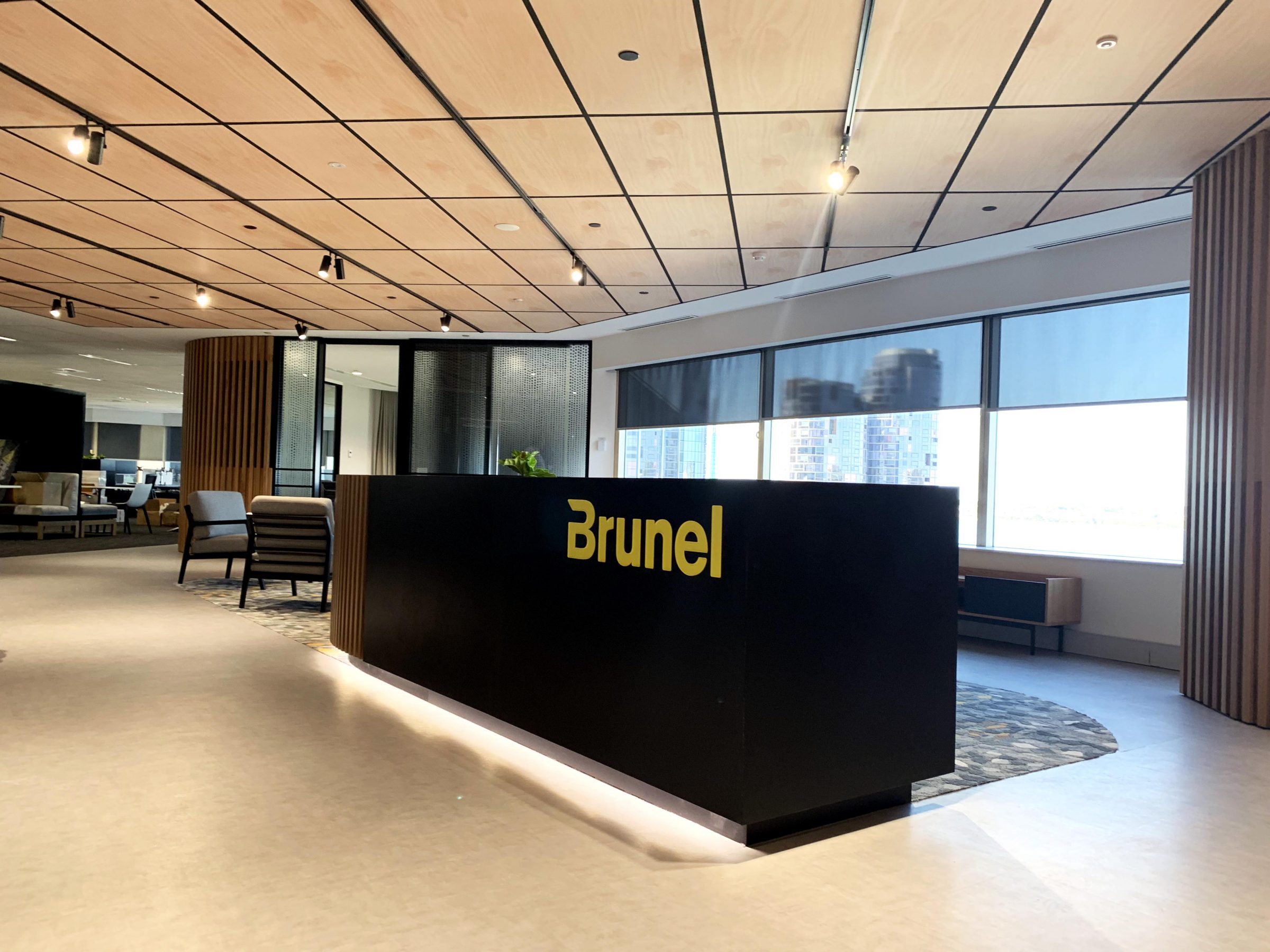 Wood reception desk with seating beyond