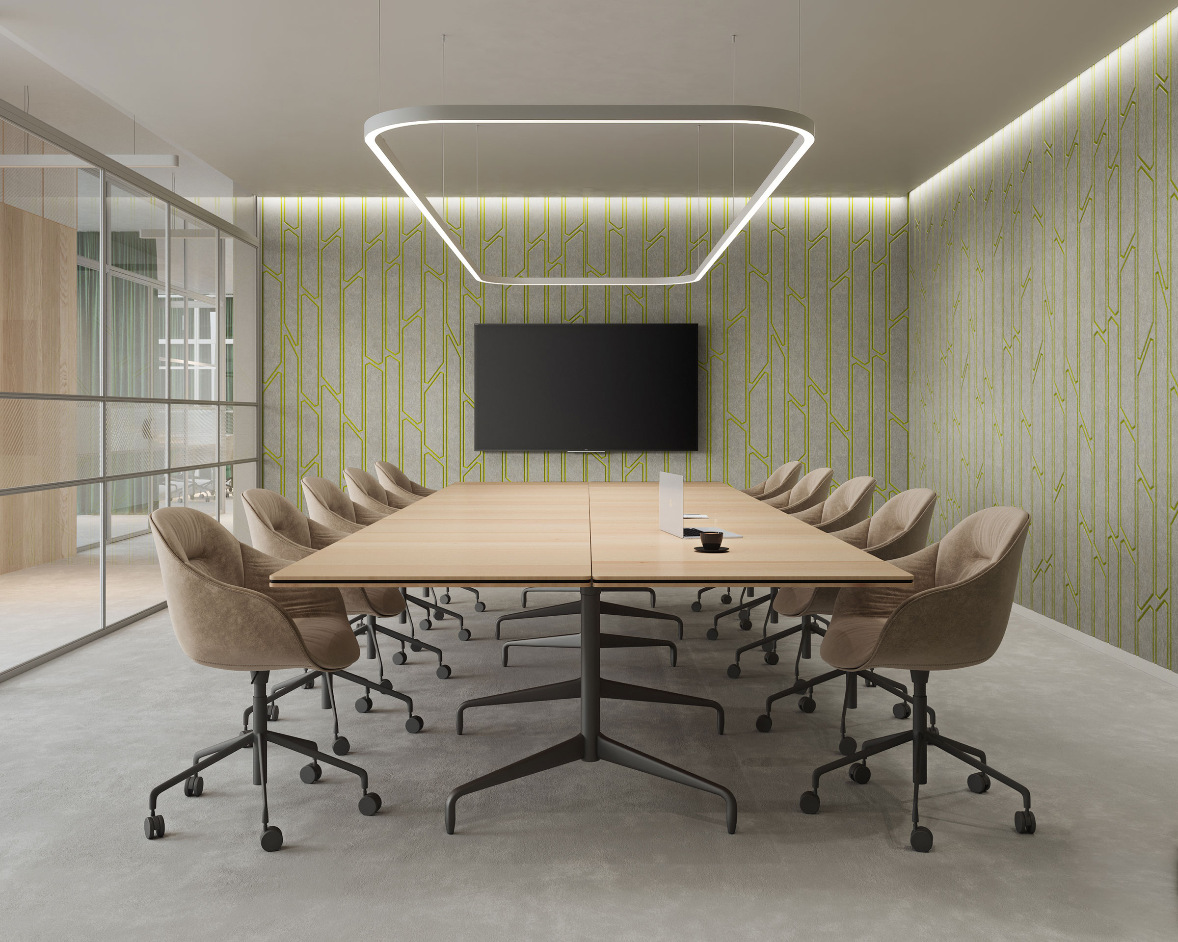 A modern conference room features a large wooden table surrounded by brown swivel chairs on a gray carpet. A flat-screen TV is mounted on a wall with a green acoustic felt wall panel. A rectangular overhead light fixture hangs above the table.
