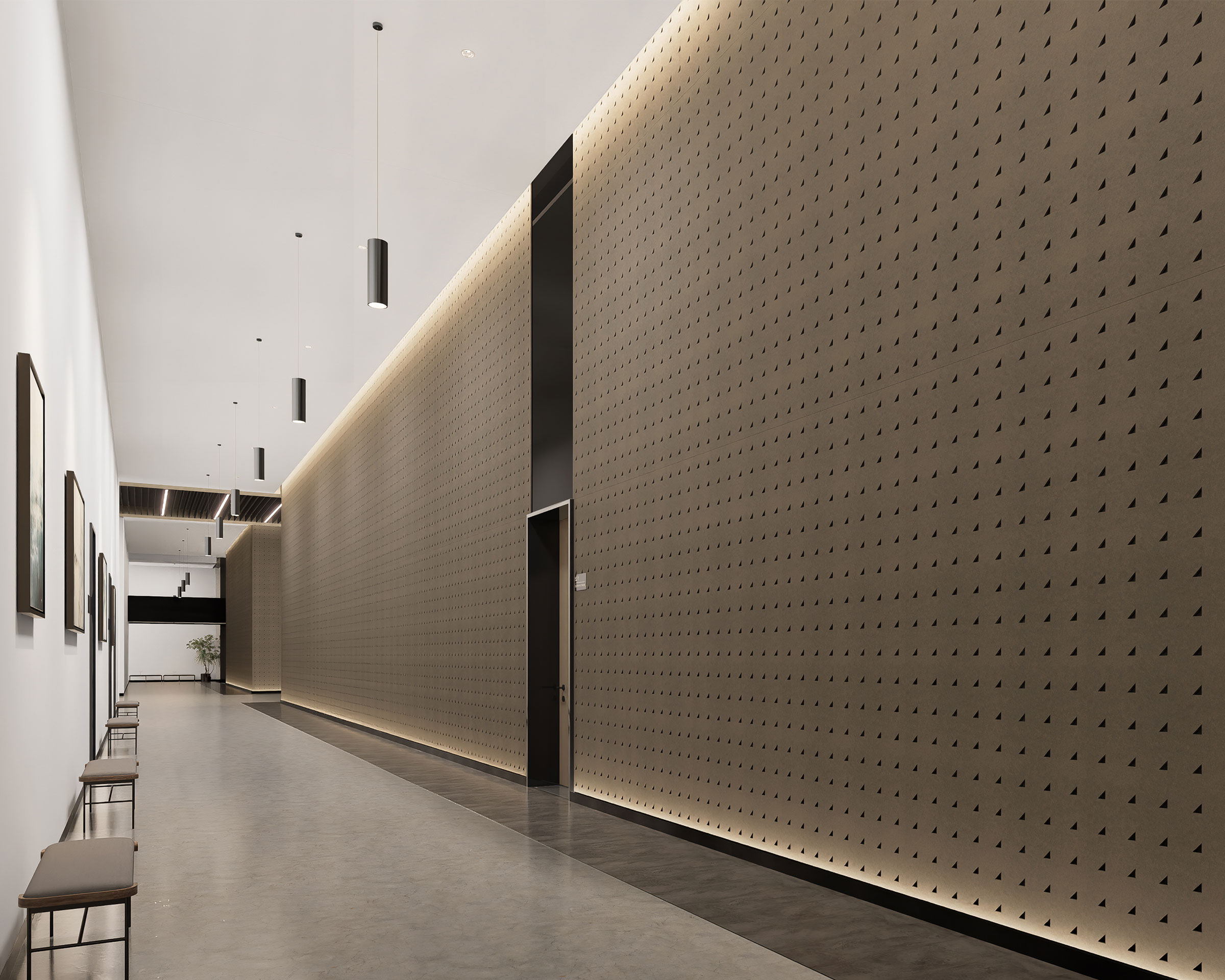 A modern, minimalist hallway with right triangle acoustic felt wall panels and sleek hanging light fixtures. The floor is gray polished concrete, and there are several benches along the white side wall. The lighting highlights the textured wall, giving the space an elegant feel.