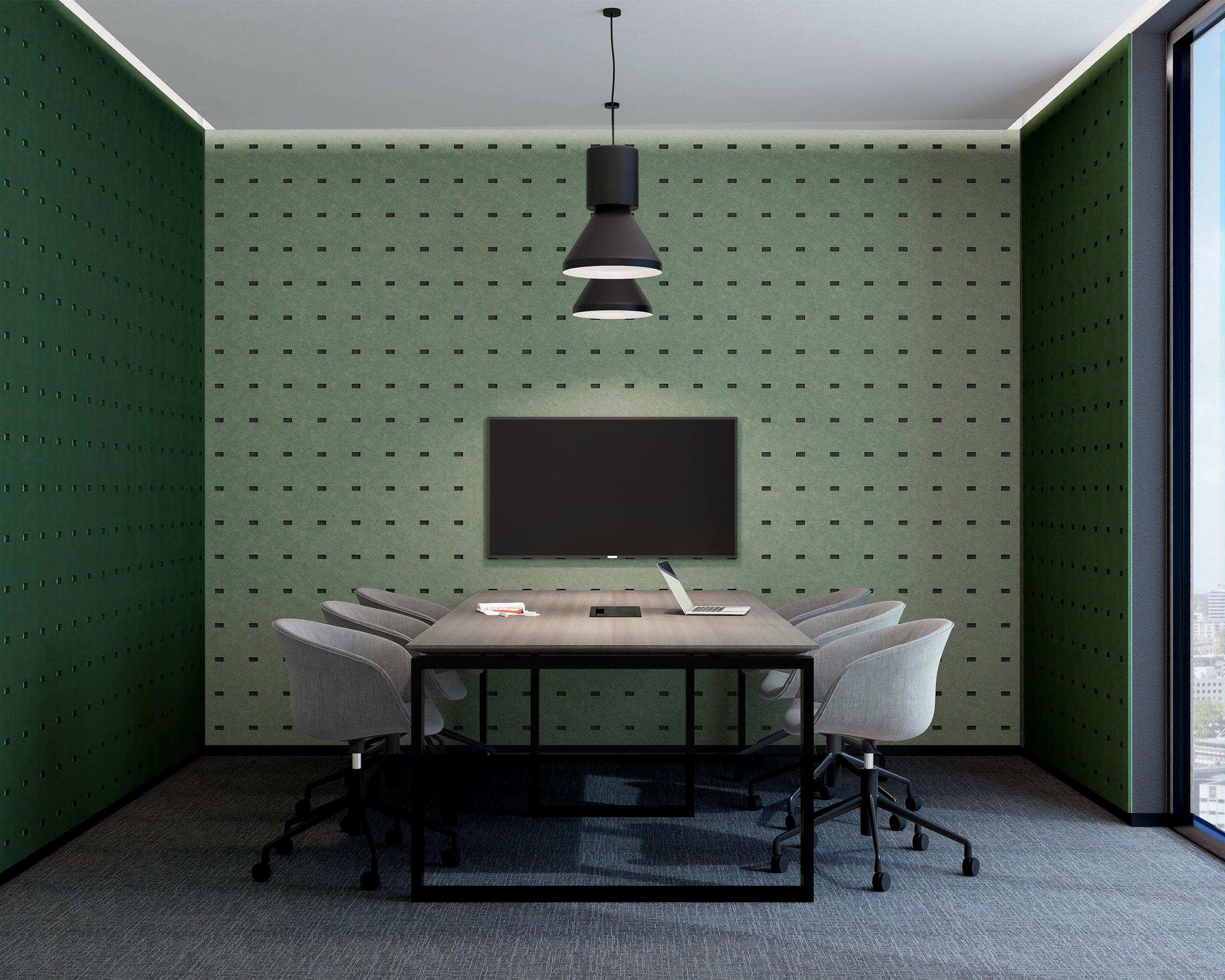 A modern conference room with a long wooden table and six gray chairs on casters. The room features a green acoustic felt wall panels with a pattern of small rectangles for sound absorption, a ceiling light fixture, a large flat-screen TV or monitor on the wall, and a large window with a city view.