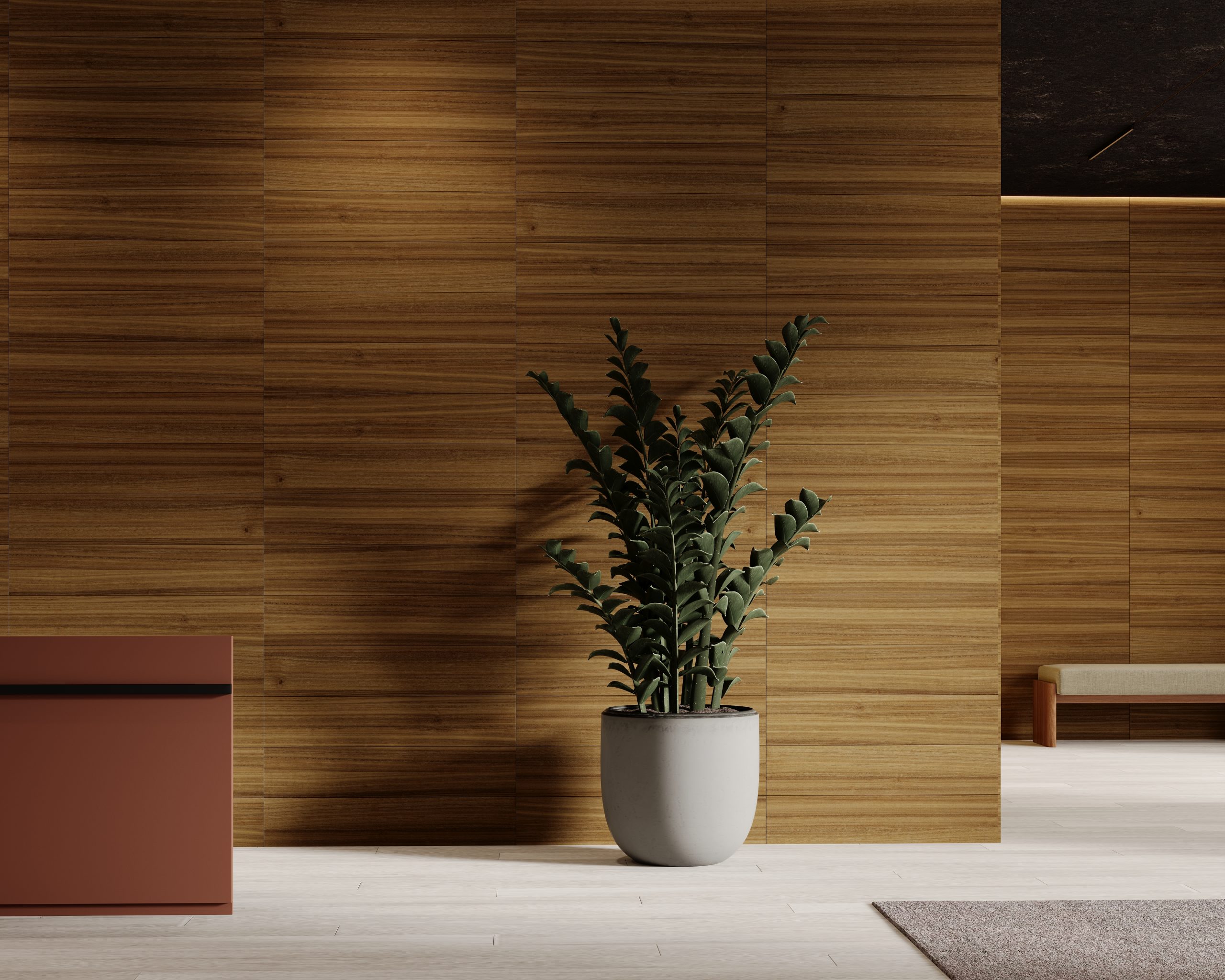 A large green potted plant with thick leaves stands in front of an acoustic felt plank wall with horizontal lines. To the left is part of a red-brown piece of furniture, and to the right, a low bench partially visible. The floor has light-colored tiles.