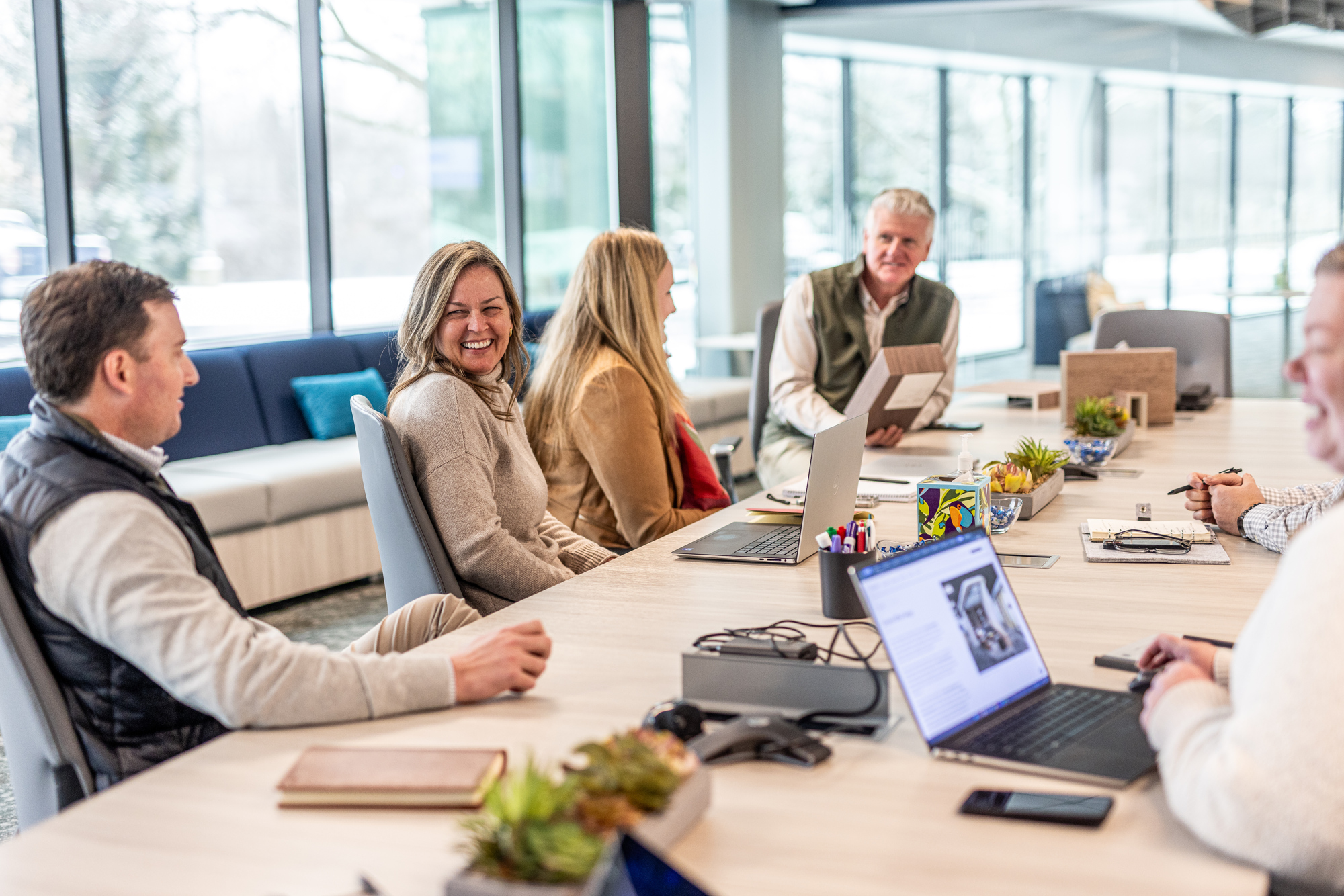 Six people gathered around conference table at Acoufelt headquarters
