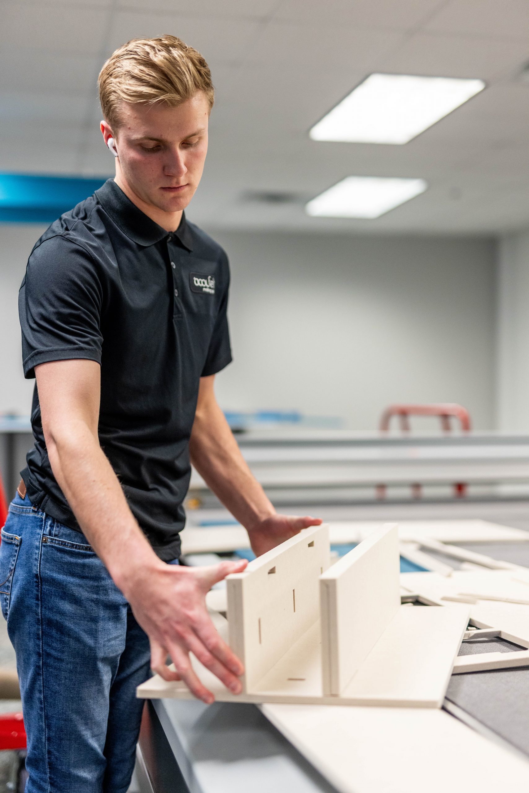 Worker holding a tool used in manufacturing Acoufelt products.