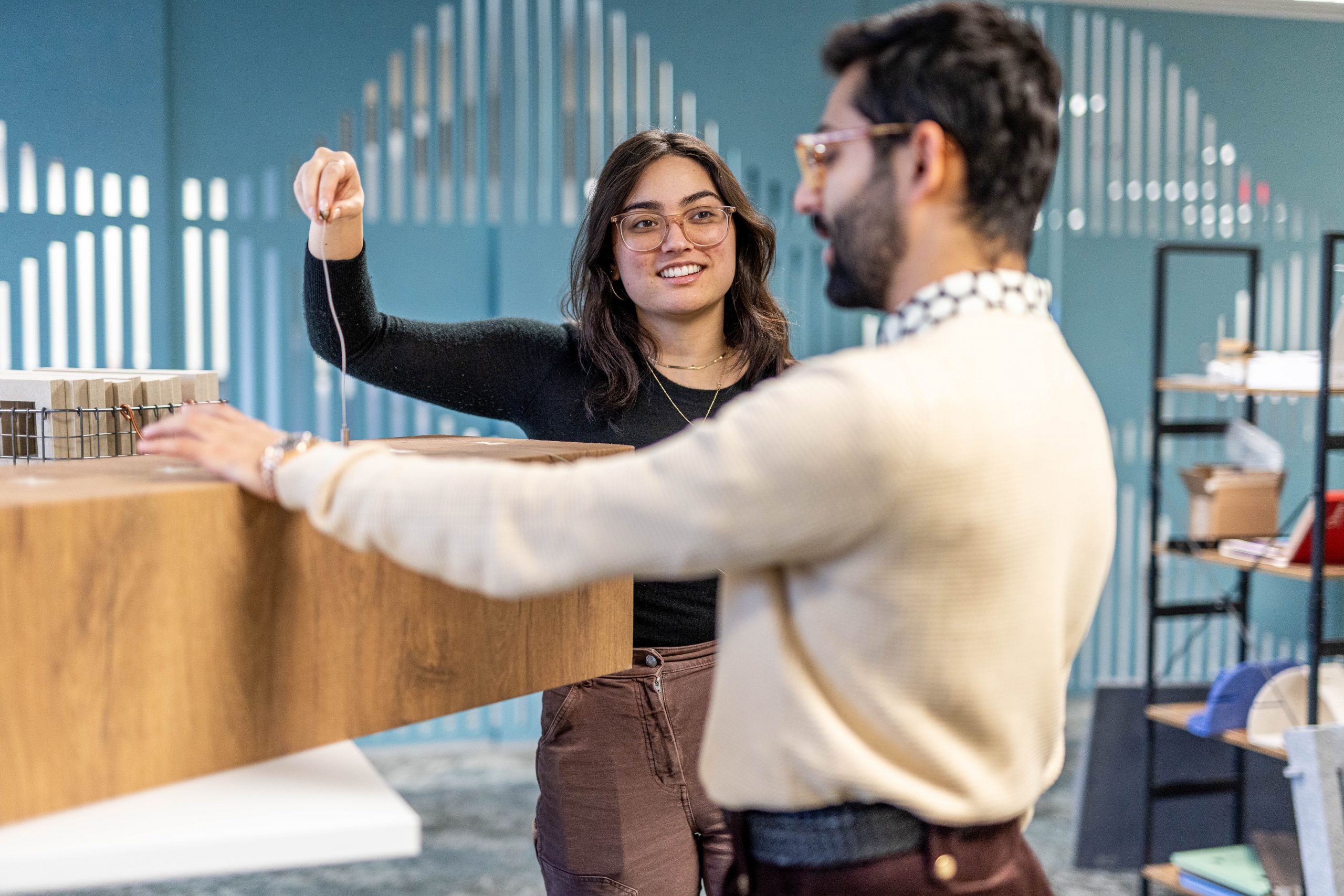 Two workers examine an Acoufelt integrated lighting solution.