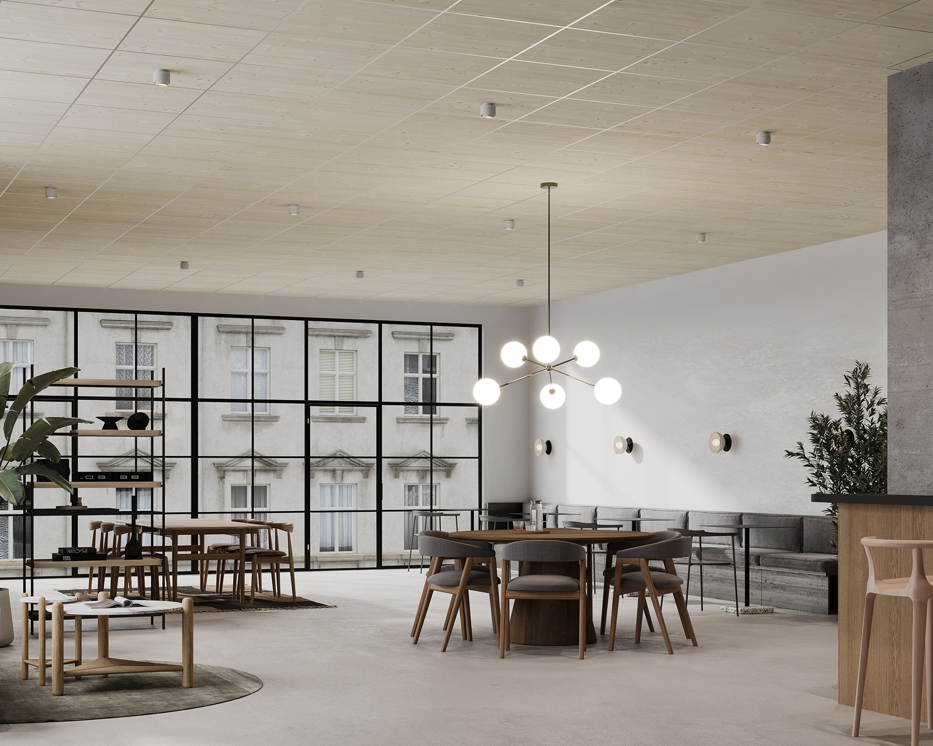 A modern office space featuring large windows, wooden furniture, an acoustic felt panel ceiling, and a circular light fixture with spherical bulbs. The room includes a conference table, chairs, a small sitting area with grey sofas, and a bar stool seating area. Natural light brightens the space.
