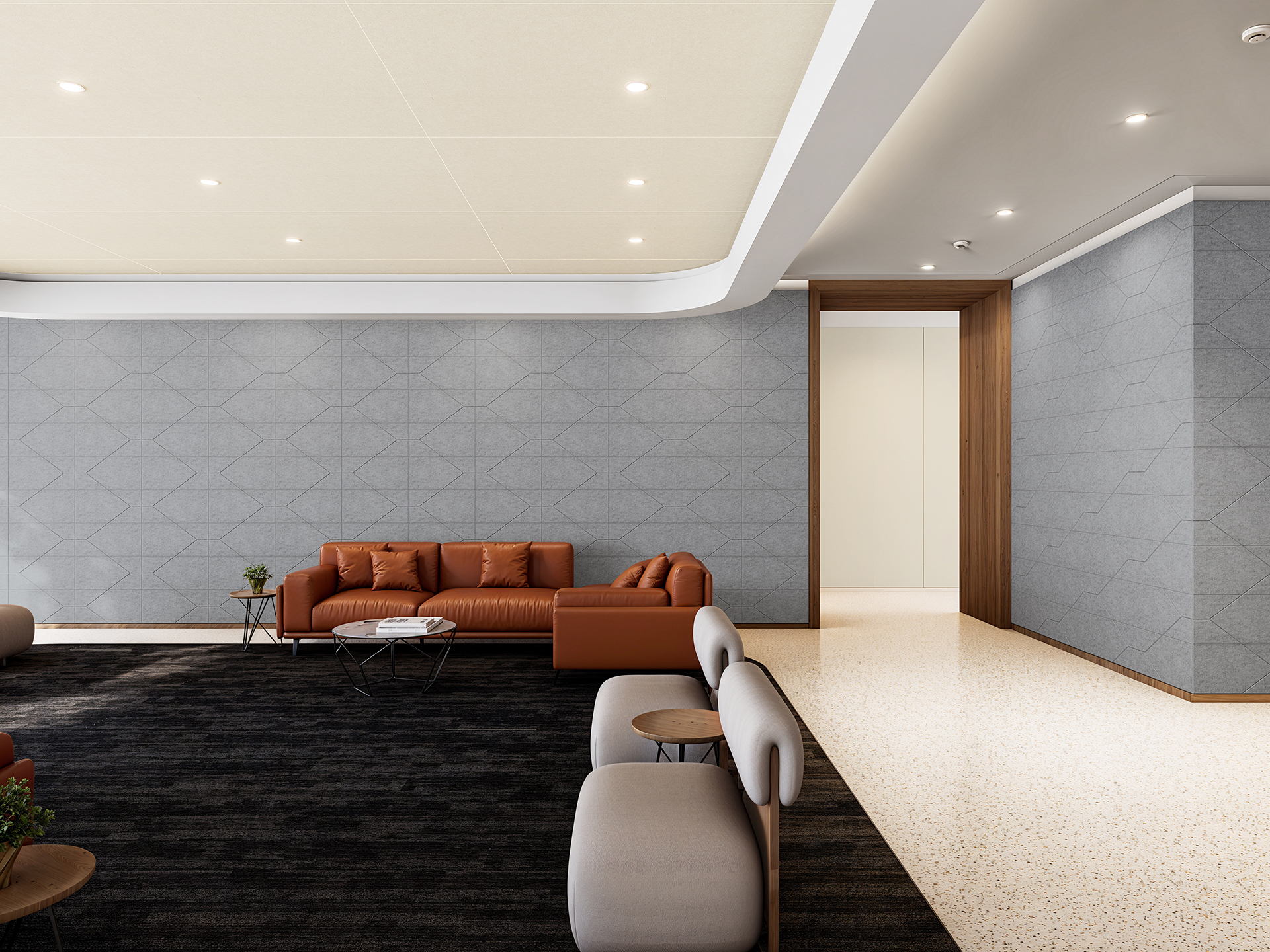 A modern lounge area with a stylish design, featuring a brown leather couch, two round wooden coffee tables, and beige armchairs. The room has a grey geometric acoustic felt patterned wall, recessed lighting, and a combination of dark carpeting and light terrazzo flooring.