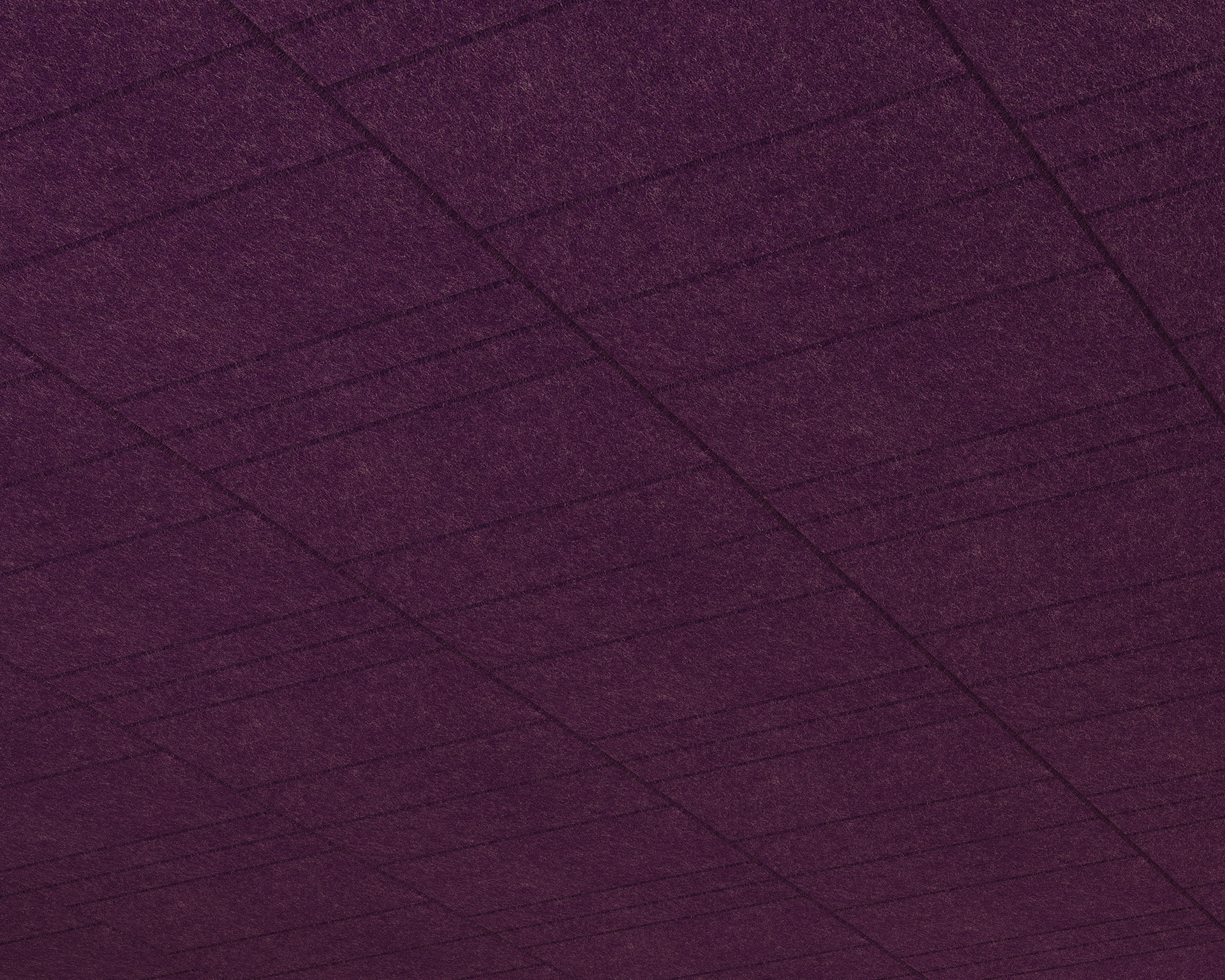 Close-up of a textured purple acoustic felt panels with horizontal and vertical stitch lines creating a grid pattern. The surface has a soft, wool-like appearance.