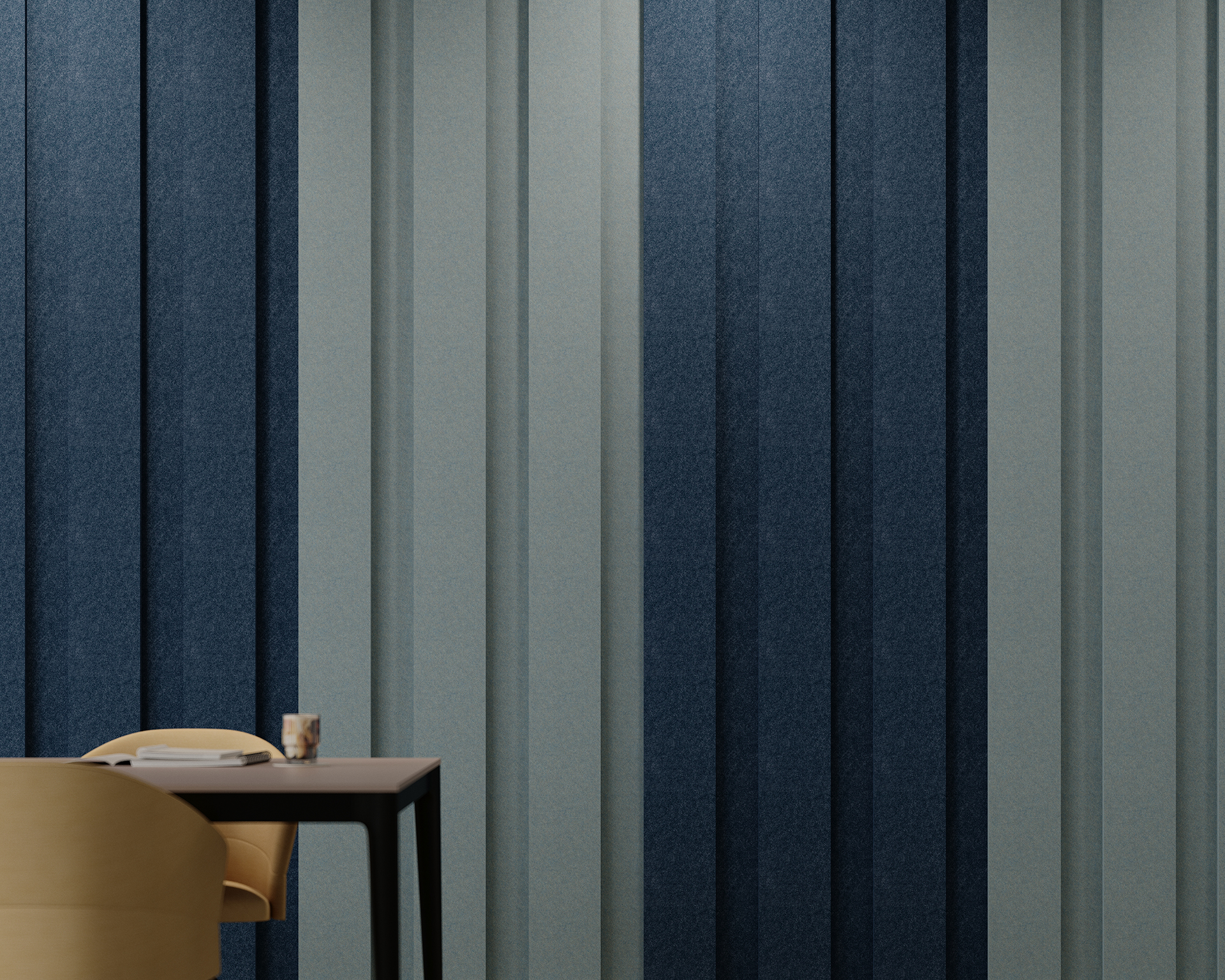 A modern interior features a textured wall with vertical bands in shades of blue and gray created by etched acoustic felt wall tiles. In the foreground, a beige chair is partially visible next to a dark table holding books and a small wooden object.