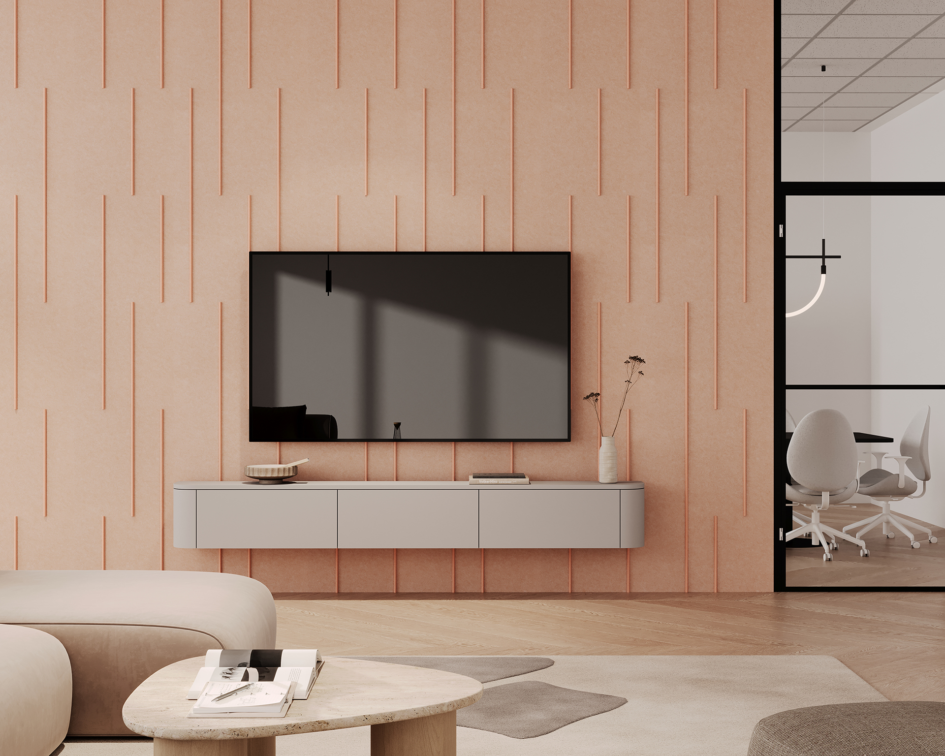 Modern living room with a wall-mounted TV on a peach acoustic felt accent wall featuring vertical lines. Below the TV is a floating gray console with decor items. In the foreground, a round wooden table and neutral-toned furniture. A glass partition reveals an office space.