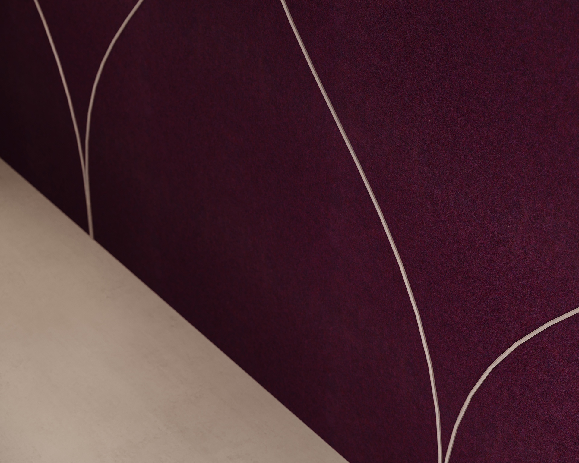 Close-up of a textured dark maroon acoustic felt wall with curving thin white lines forming abstract shapes. At the bottom, a light beige surface creates a contrasting horizontal edge.