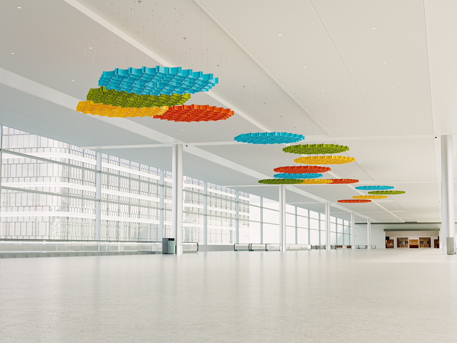 A spacious, modern interior with large windows and colorful, circular acoustic felt ceiling art installations in blue, orange, green, and yellow. The space is bright, open, and mostly empty, with a few distant doors and a trash can.