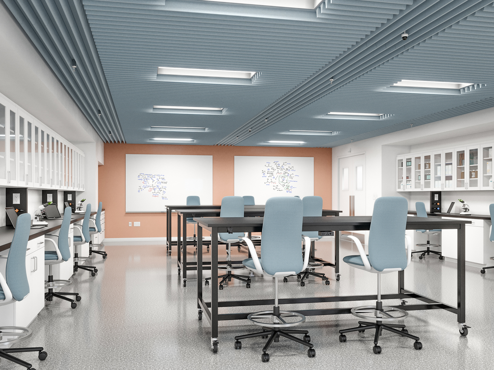 Modern science lab with high tables and blue chairs, an acoustic felt ceiling, microscopes on workstations, glass cabinets, and whiteboards with diagrams on the walls. The room has a clean, bright, and organized appearance.