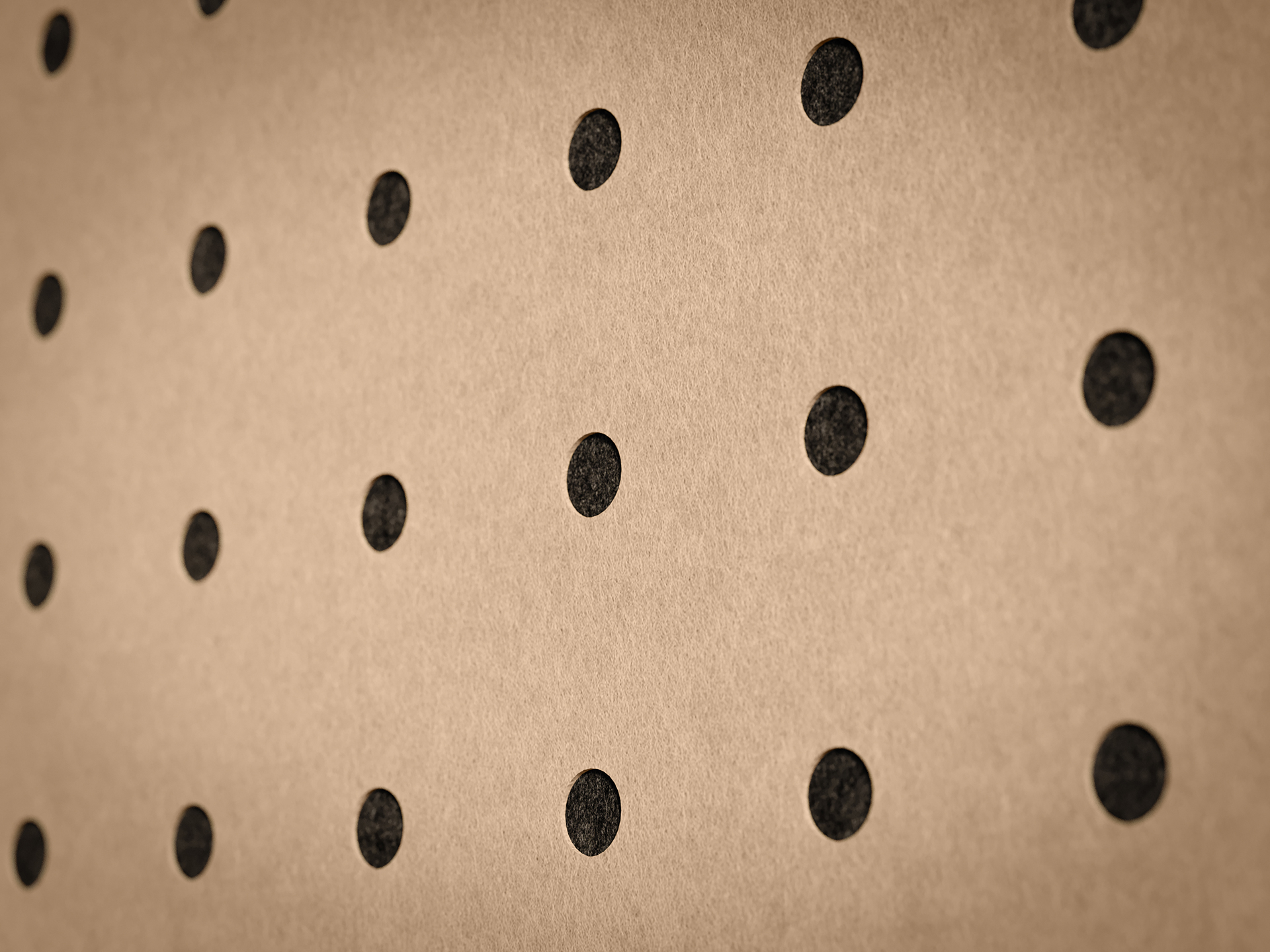 A close-up of a brown acoustic felt wall with evenly spaced black dots arranged in a grid pattern.