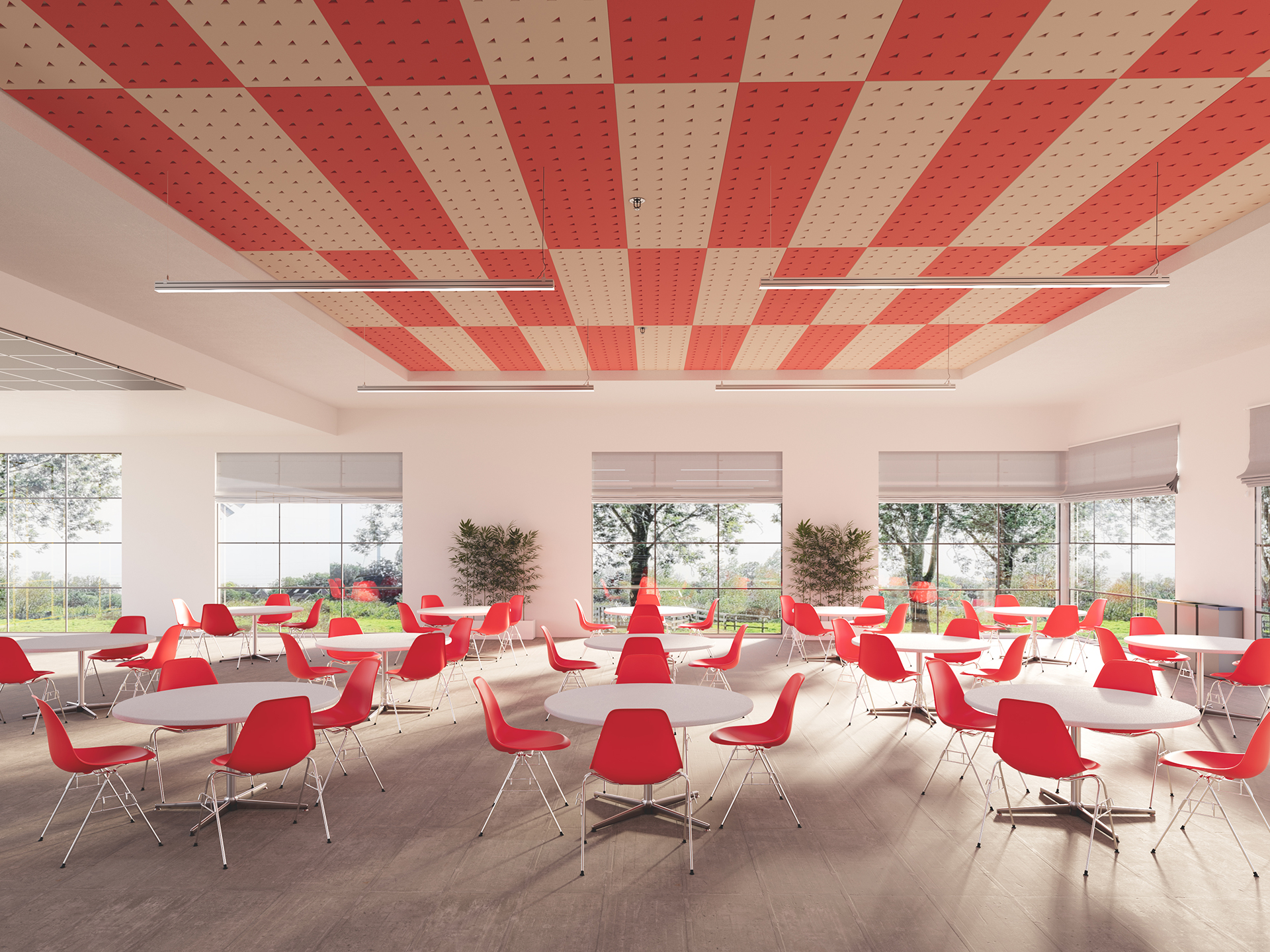 A modern cafeteria with red and white checkered acoustic felt ceiling, large windows, and round tables surrounded by red chairs. Sunlight fills the room, and green trees are visible outside.