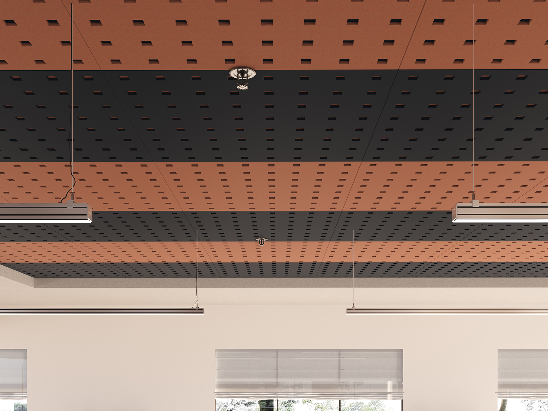 Ceiling with alternating orange and dark gray acoustic felt panels featuring a grid of small square holes; two linear hanging lights and a sprinkler head are visible, above windows with roller blinds.
