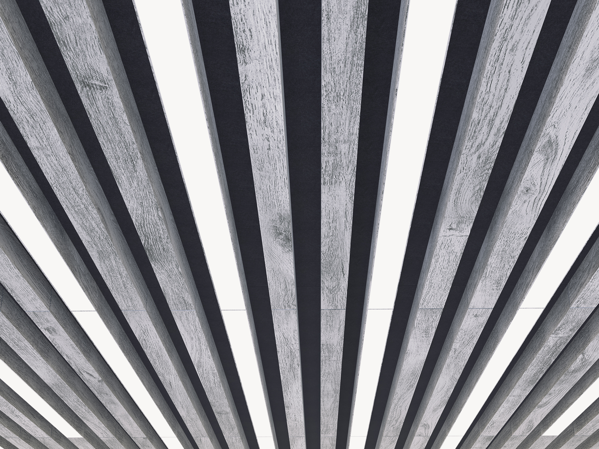 View looking up at an acoustic felt ceiling with evenly spaced, alternating light gray and black wooden beams, creating a striped pattern with light shining through the gaps.