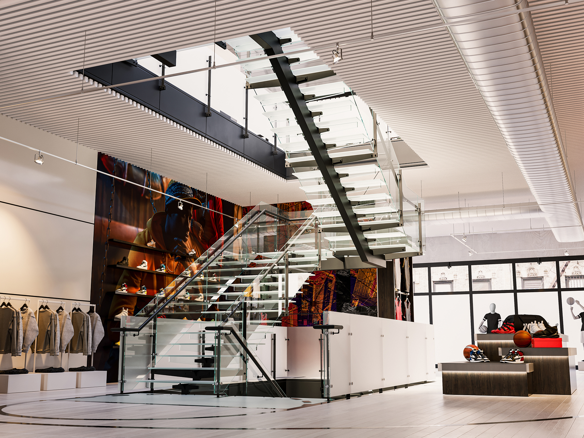 A modern retail store with a central glass staircase, glass railings, clothing racks on the left, and a display area with basketballs and mannequins on the right. Large windows let in natural light.