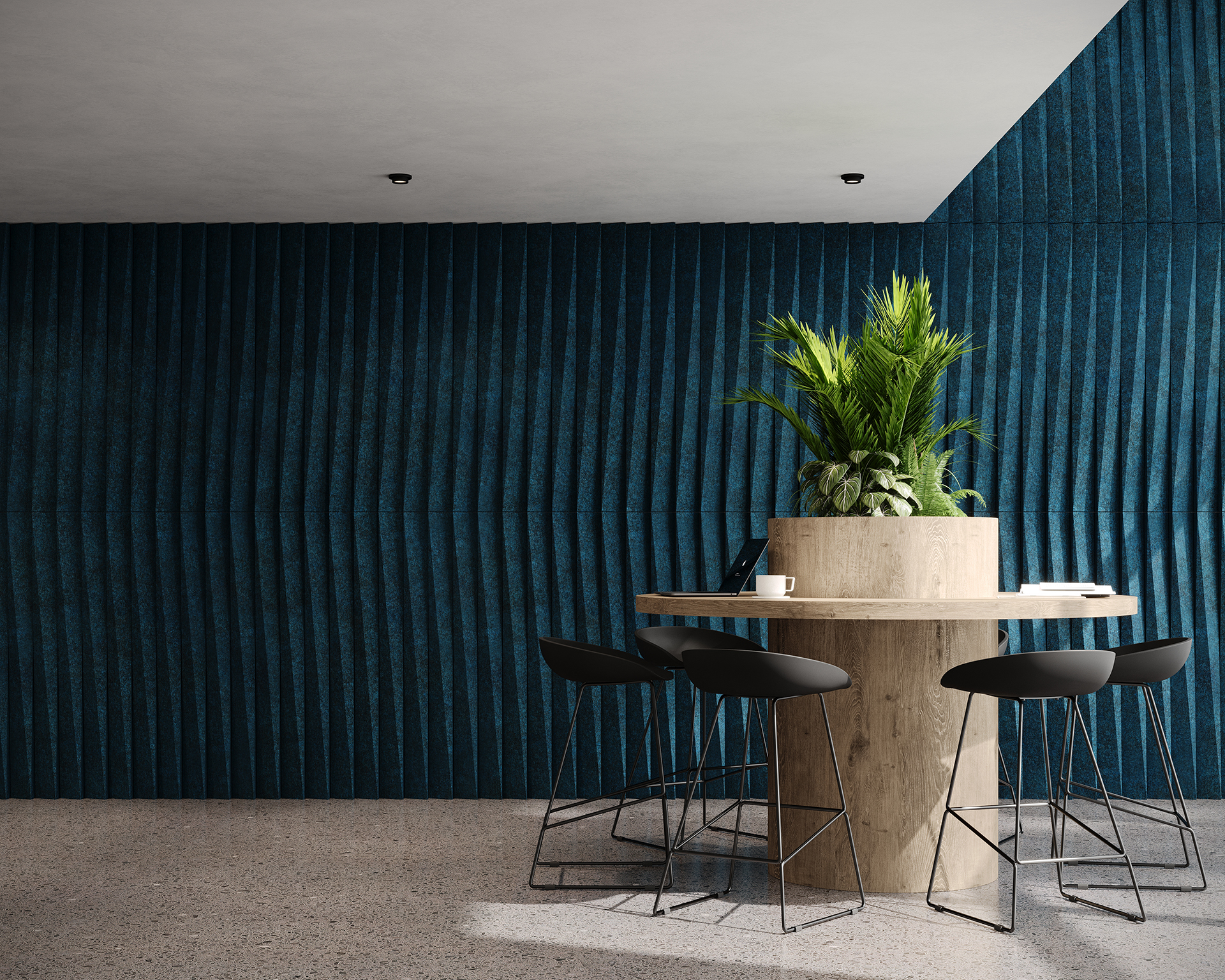A modern round wooden table with four black chairs and a potted plant sits in front of a dark blue, textured wall in a minimalist, well-lit room with a light floor.