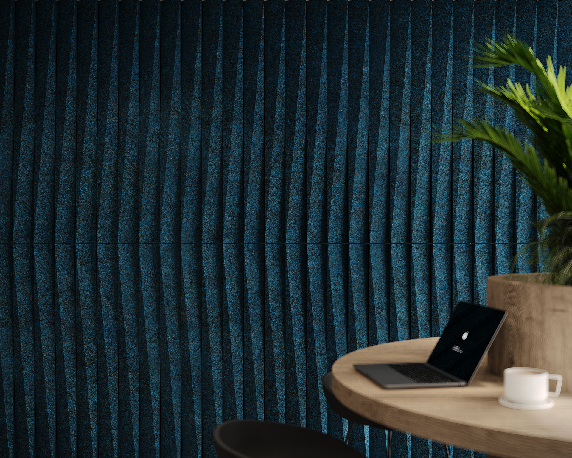 A dark blue, textured, vertically-rippled wall is behind a round wooden table with a laptop, white coffee mug, and a green potted plant. Part of a black chair is visible on the left.