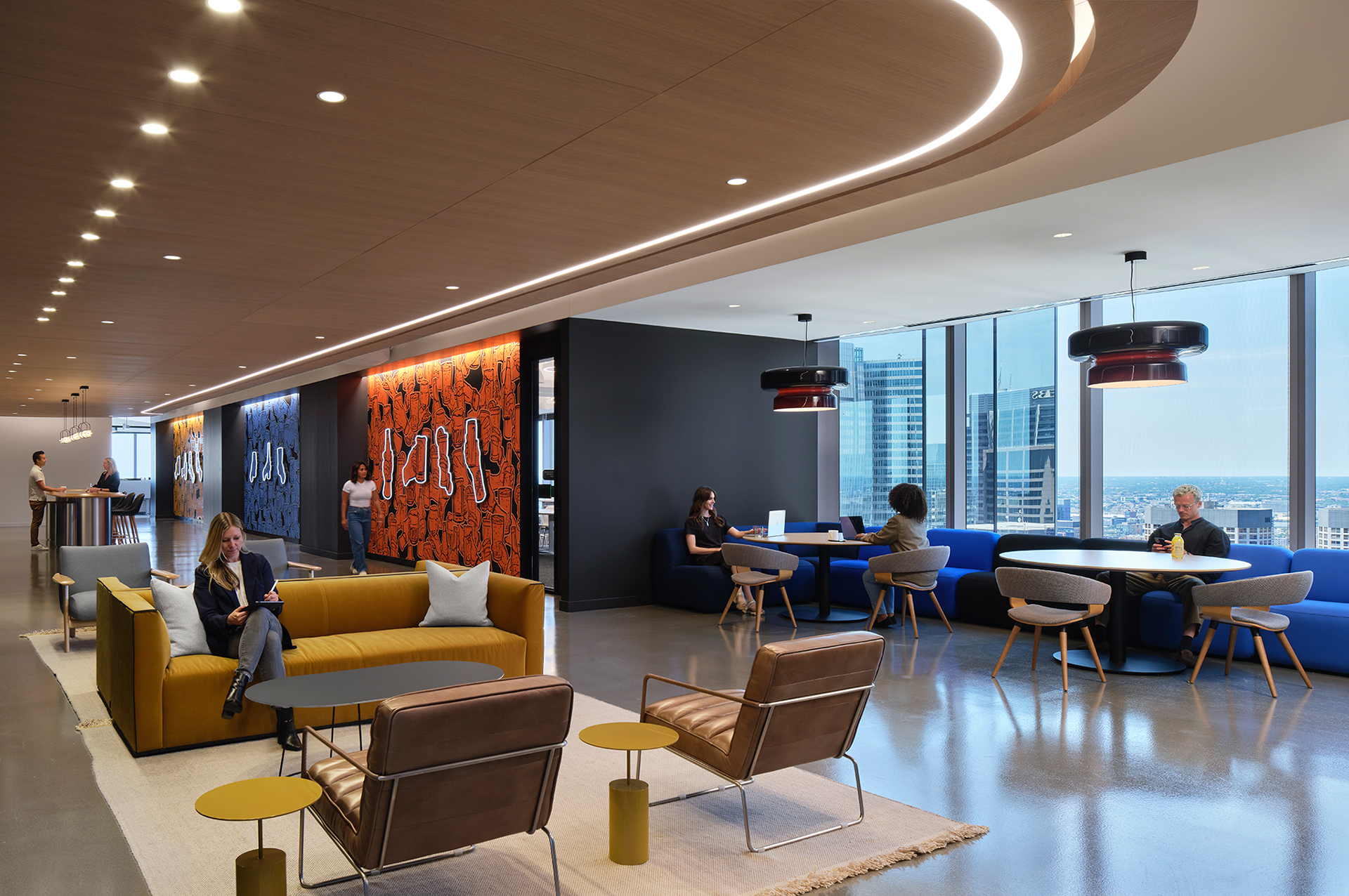 Modern office lounge with people working and talking. The space has stylish sofas, armchairs, and round tables, with large windows offering city views and colorful wall art for decoration. Bright, open, and contemporary atmosphere.