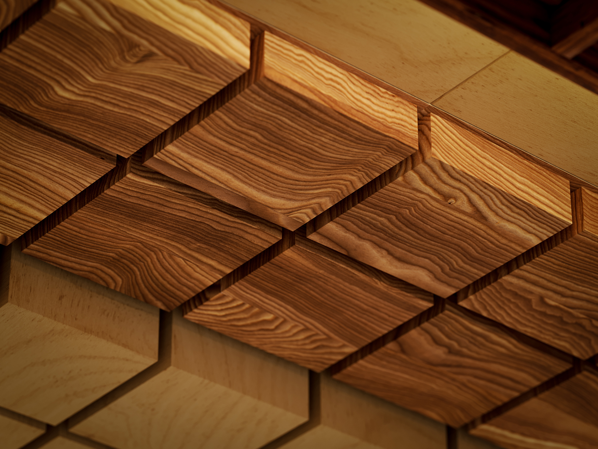 Close-up of a woodgrain acoustic felt ceiling with a geometric pattern made of square, textured wooden tiles arranged in a grid, creating a three-dimensional effect. Natural wood grain is visible, giving a warm and rustic appearance.