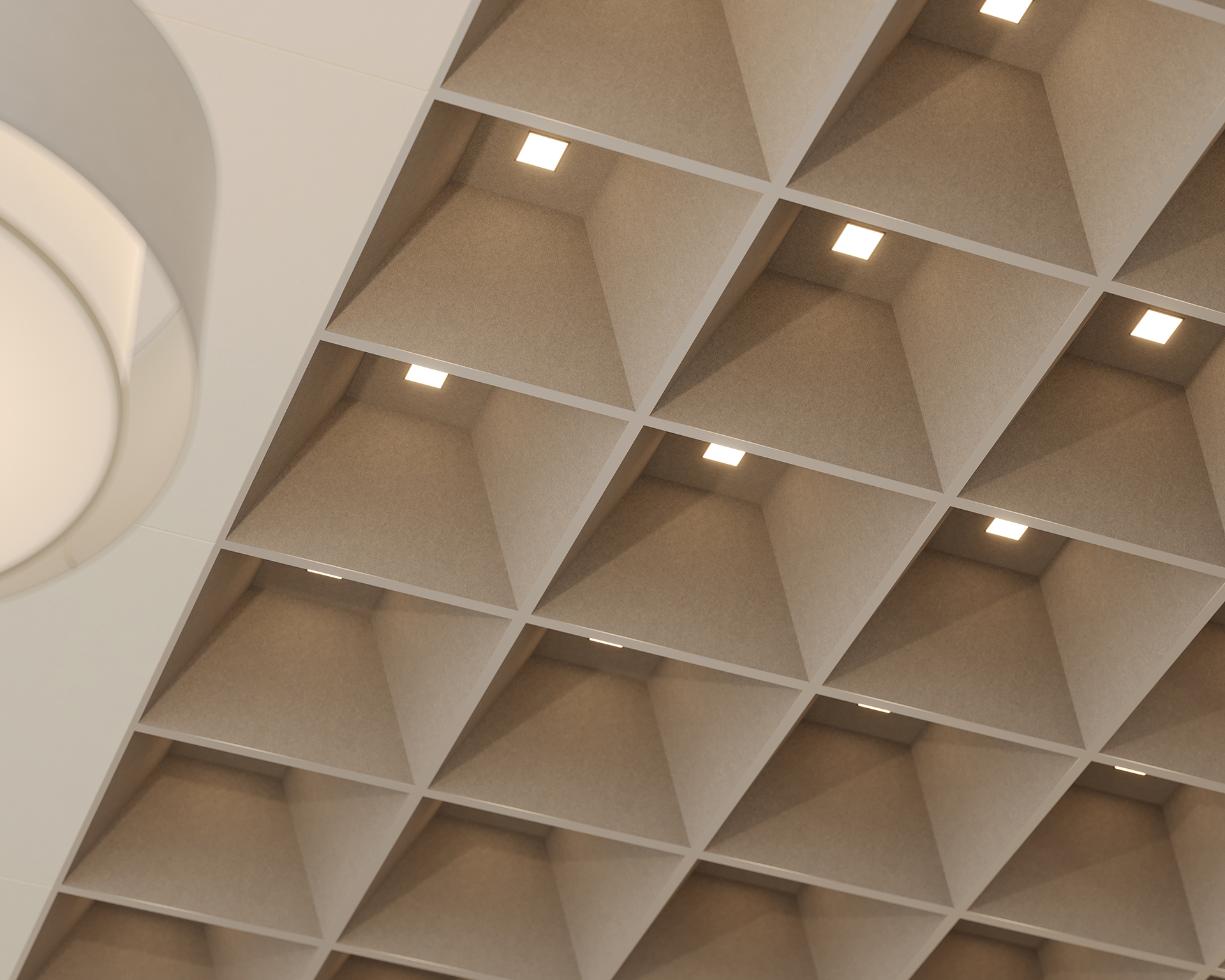 A modern ceiling with an acoustic felt grid pattern of recessed square lights set in deep, angled compartments. The neutral tones and clean lines create a geometric, contemporary look. A round light fixture is partially visible on the left.