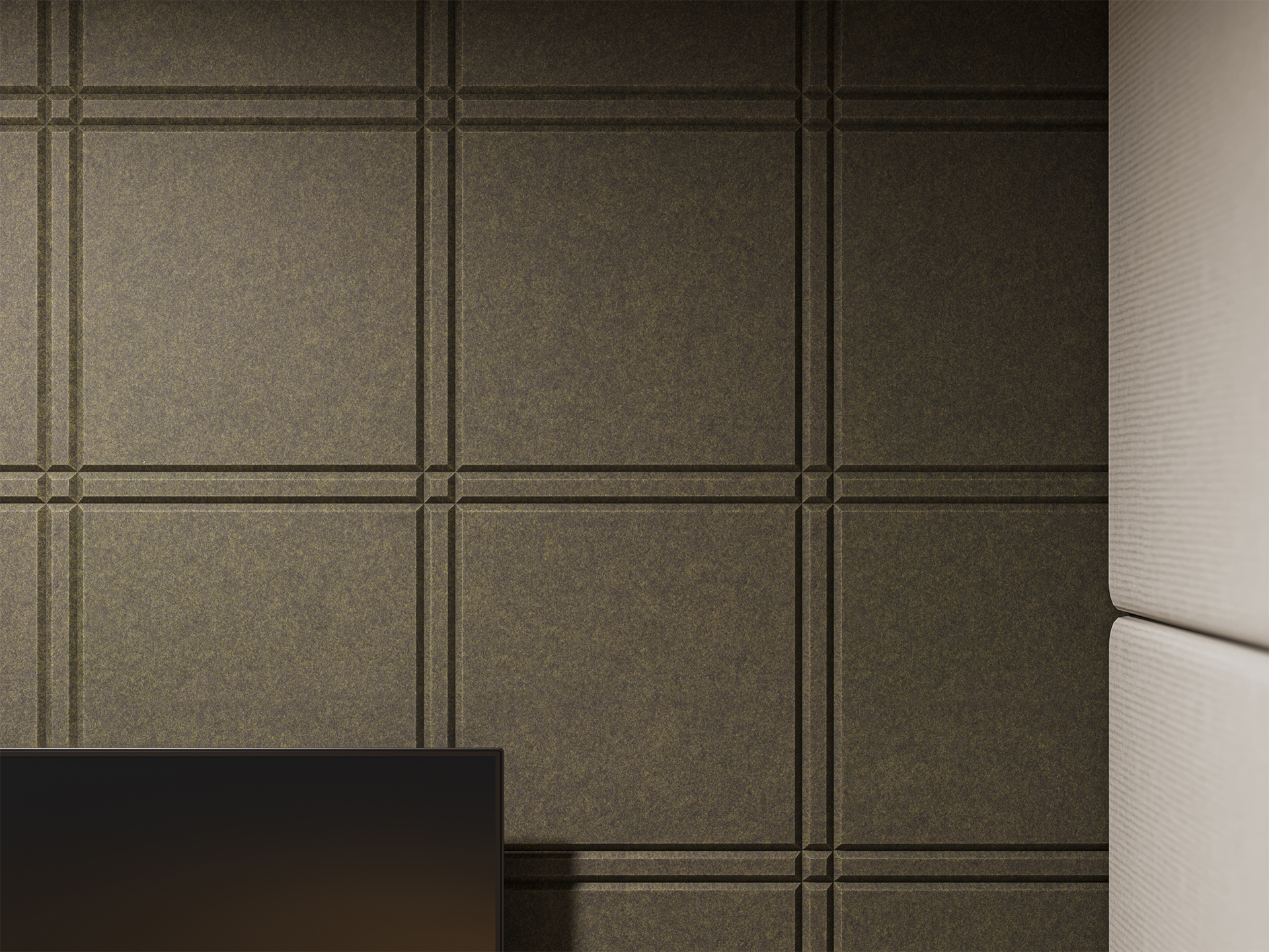 Textured acoustic felt wall with a grid pattern of raised square panels and small notches at the corners; a light-colored, cushioned surface is visible on the right side, and part of a dark rectangular object appears at the bottom left.